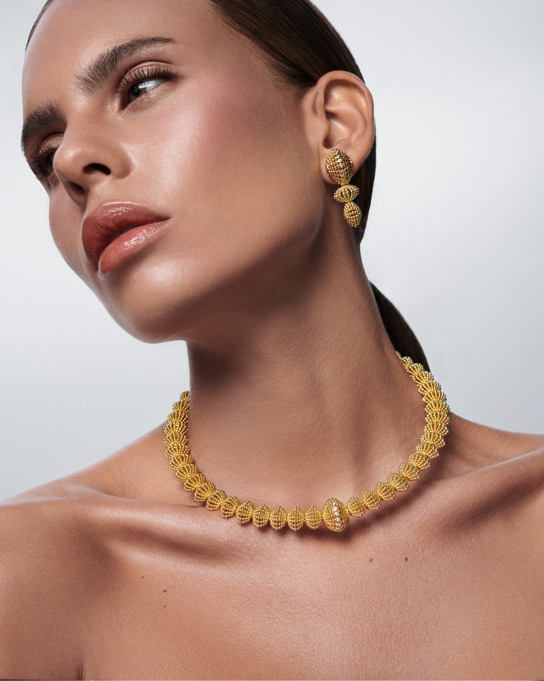 Elegant gold dangle earrings and necklace from the Ravi Nova Collection