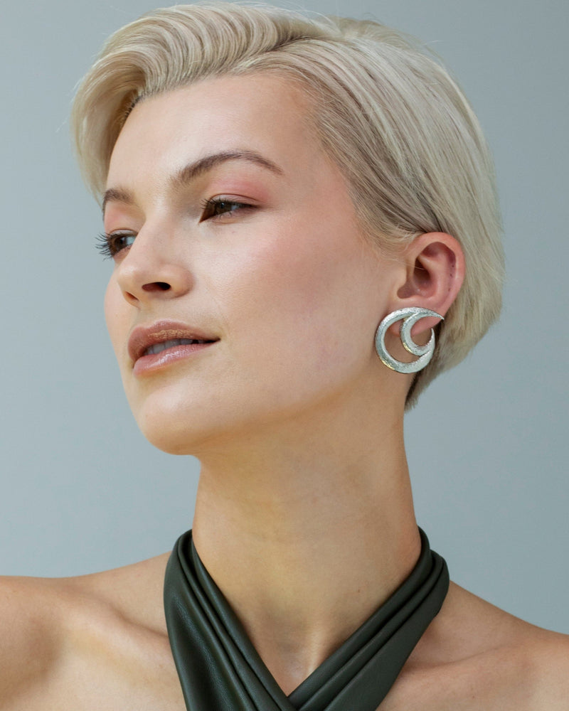 Sculptural silver earrings with moonlit design