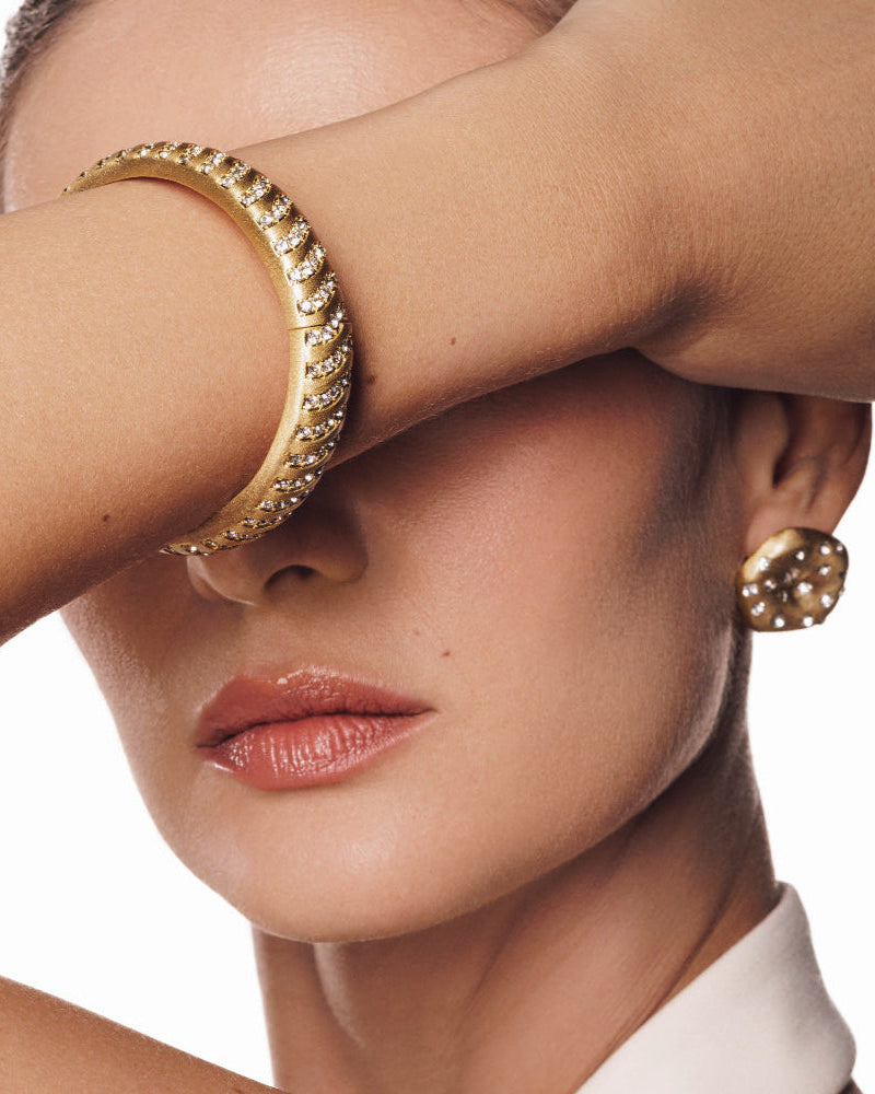 Layered gold bangles featuring Aurora Wave design