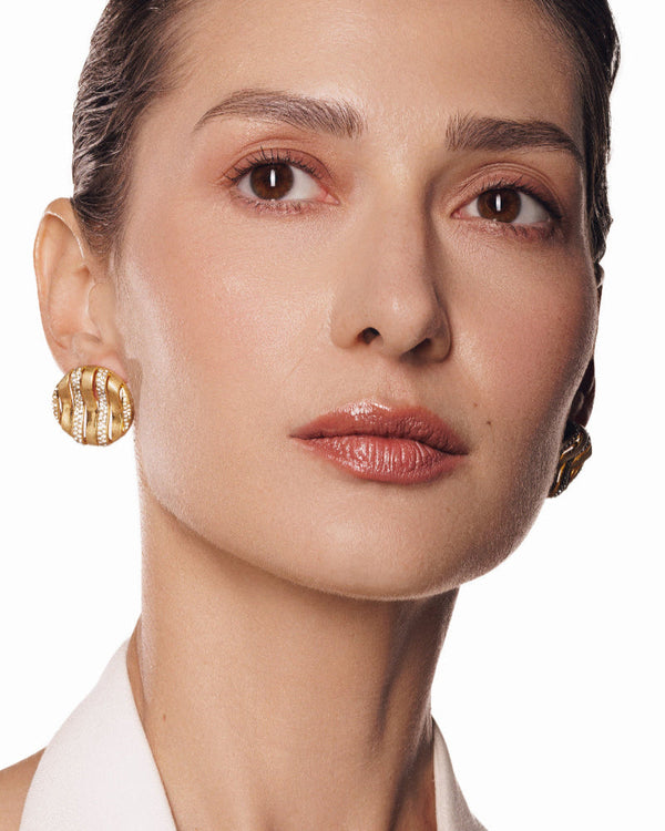 Close-up of wavy striped gold statement earrings