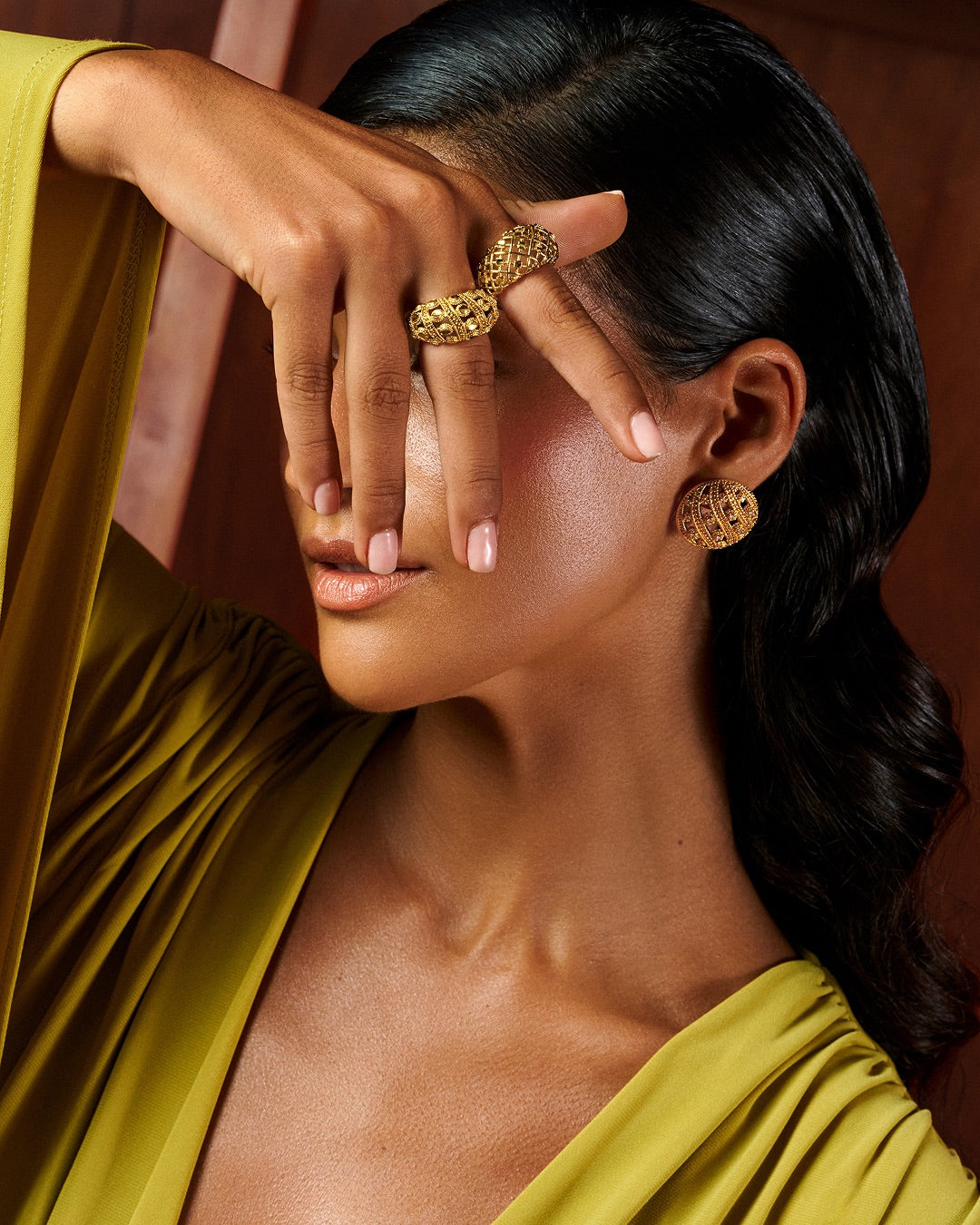 A shell-inspired and woven statement ring in 24K gold plating paired with round statement earrings