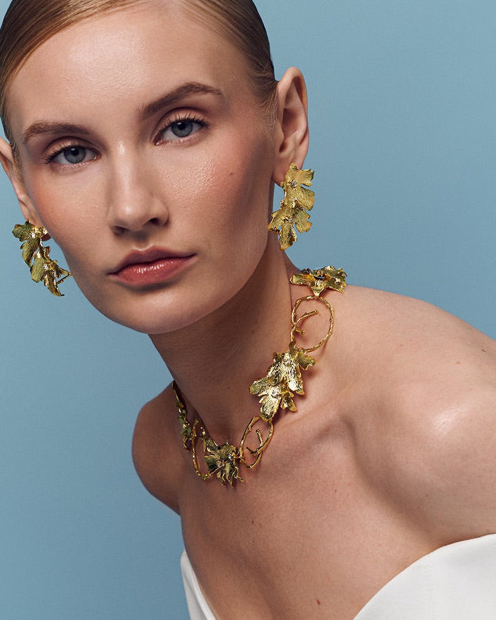 Gold leaf ear cuff paired with necklace with nature-inspired design, ideal for stacking with gold huggie earrings or wearing solo for a minimalist yet bold style.